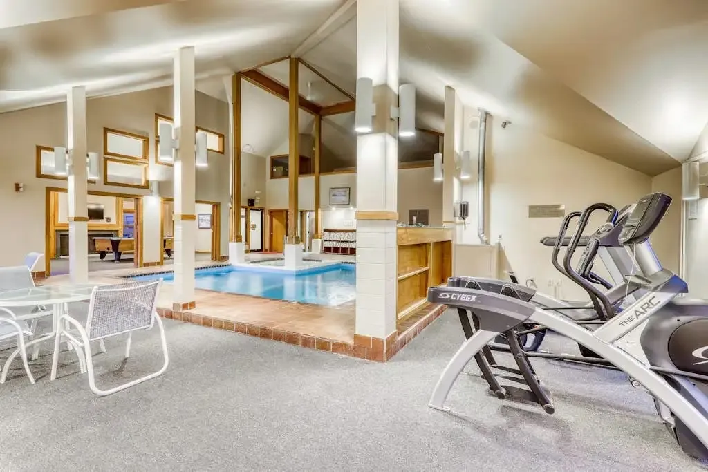 Fitness room with cardio equipment overlooking the indoor pool area