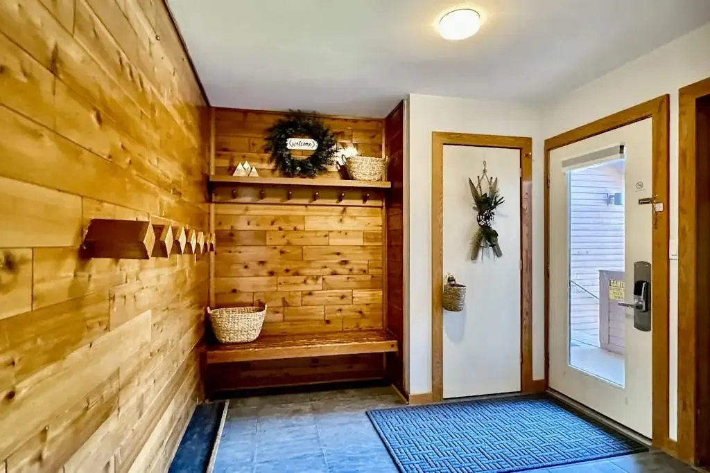 Entryway with coat hooks and a bench beside the front door