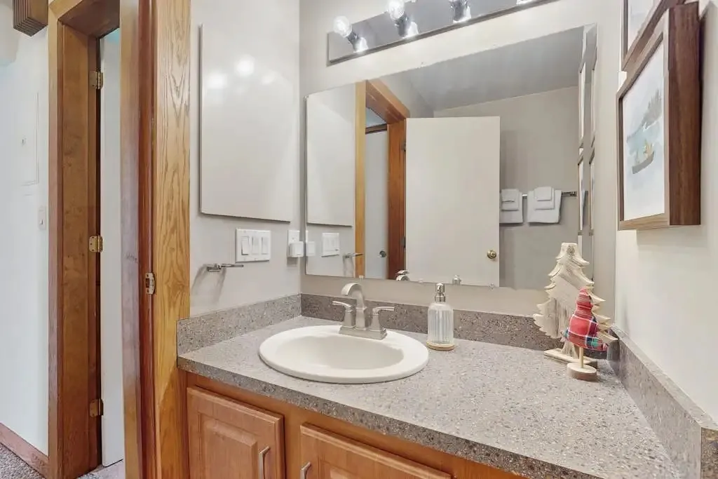 Second bathroom vanity with a wood-framed mirror and nautical artwork